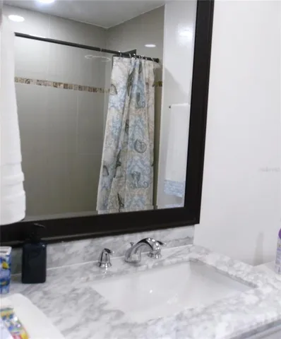 a bathroom with a granite countertop shower a toilet and a shower