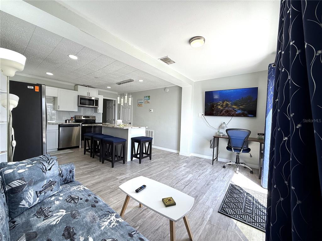 13711 Gulf Boulevard, Unit 1 Madeira Beach, FL 33708 - Photo 24 of 36 a living room with furniture and a flat screen tv