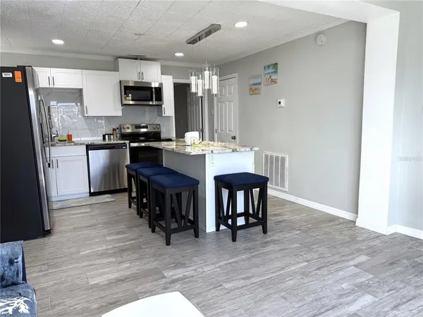 a kitchen with stainless steel appliances kitchen island granite countertop a refrigerator stove microwave and sink