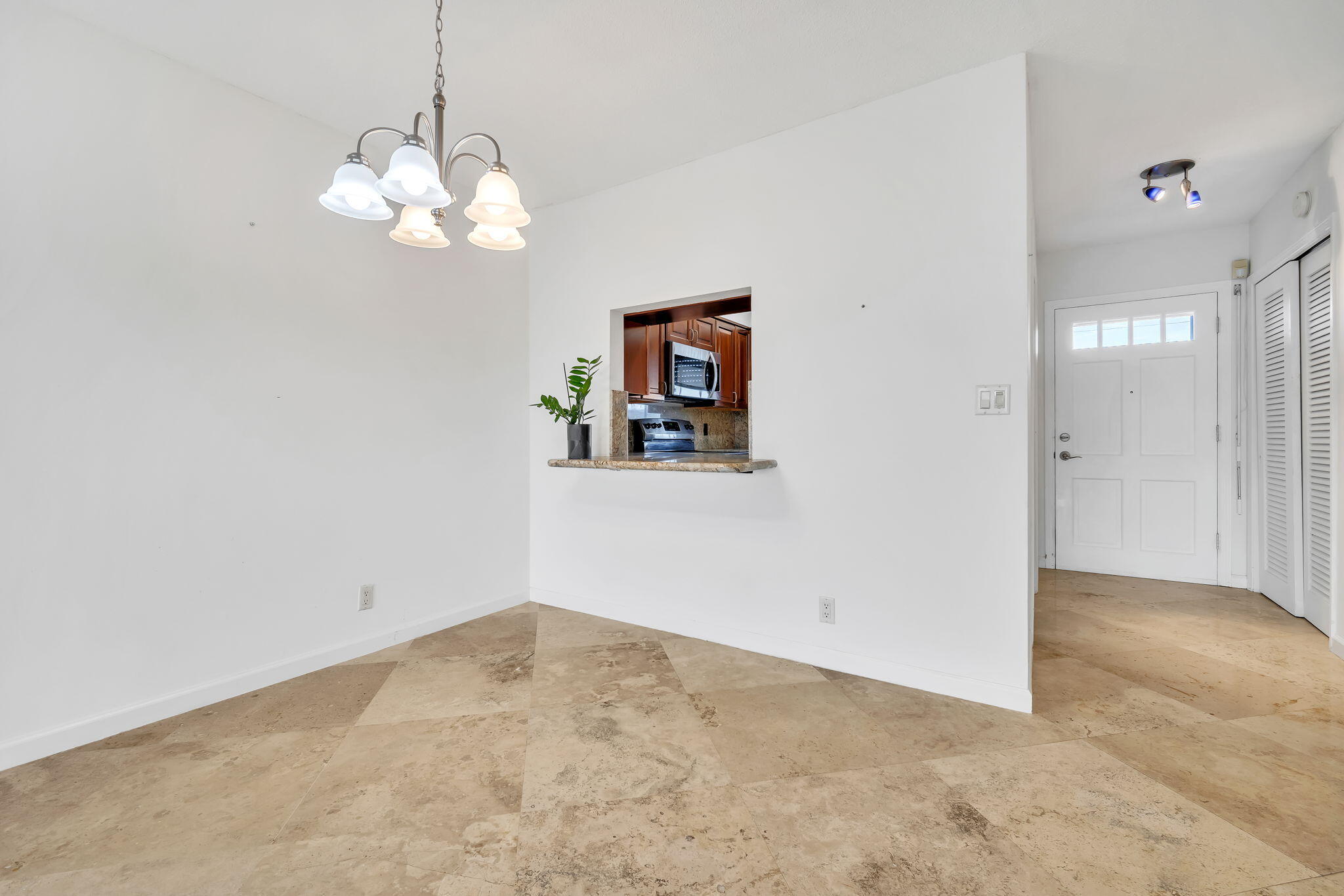 2400 Northeast 36th Street, Unit 7 Lighthouse Point, FL 33064 - Photo 13 of 27 a view of a chandelier fan and entryway
