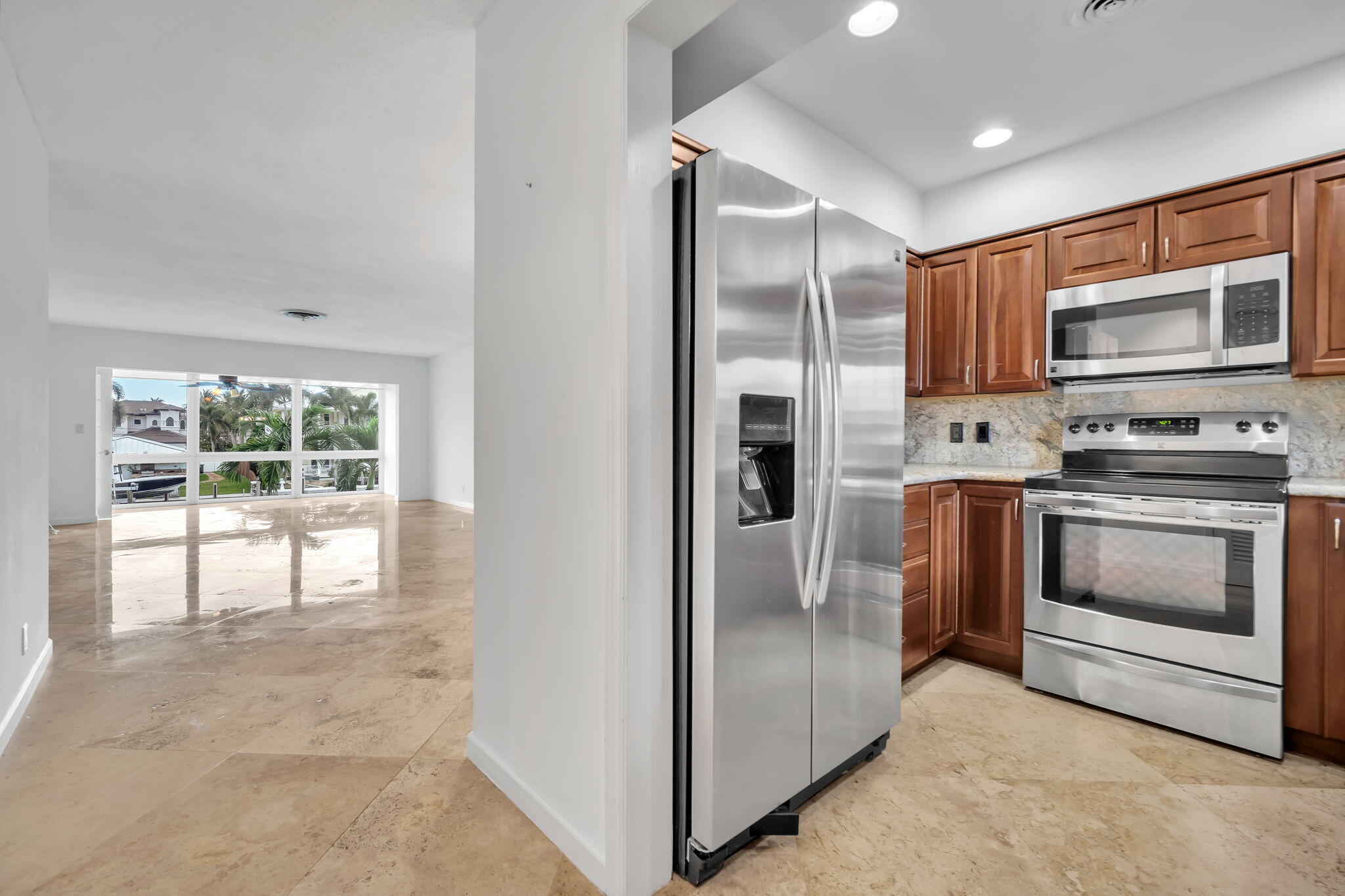 2400 Northeast 36th Street, Unit 7 Lighthouse Point, FL 33064 - Photo 6 of 27 a kitchen with stainless steel appliances granite countertop a refrigerator and a stove top oven