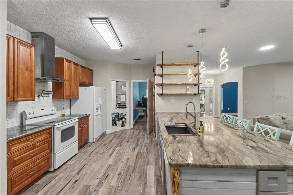 1830 Orange Tree Drive Edgewater, FL 32132 - Photo 5 of 23 a kitchen with stainless steel appliances granite countertop a lot of counter space and wooden floors
