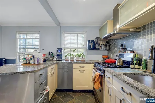 a kitchen with granite countertop a refrigerator a stove a sink dishwasher and a refrigerator