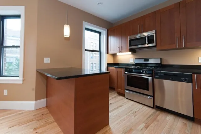 a kitchen with stainless steel appliances granite countertop a stove a microwave and a sink