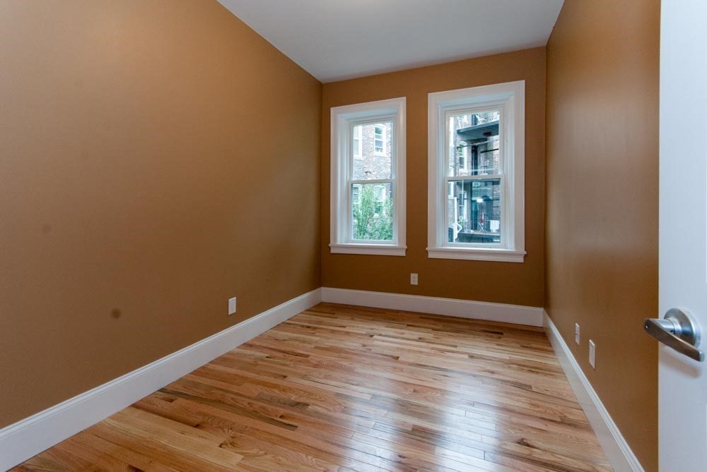 6 Lothian Road, Unit 3 Boston, MA 02135 - Photo 2 of 10 an empty room with wooden floor and windows