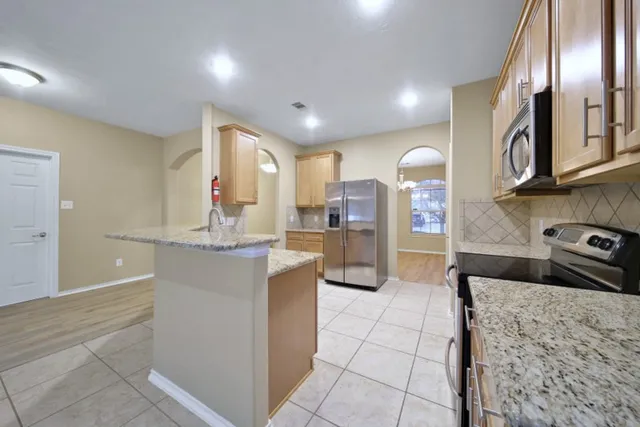 a kitchen with stainless steel appliances granite countertop a sink and cabinets