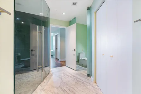 a bathroom with a glass shower door a sink and a mirror