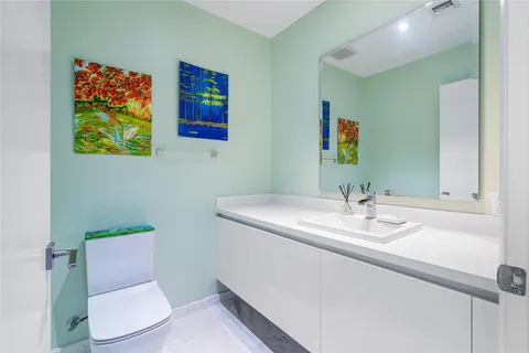 a bathroom with a toilet sink and mirror