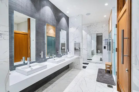 a en suite bathroom with double vanity sinks a large mirror and a shower