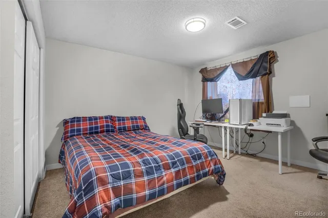 a bedroom with a bed a desk and chair