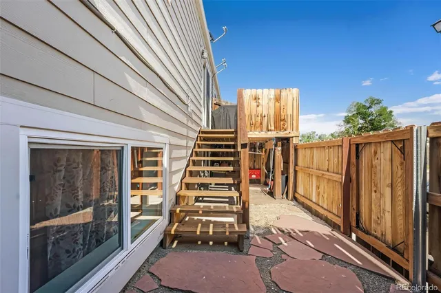 a view of a backyard with wooden fence and a floor to ceiling window