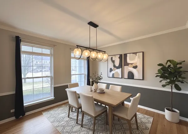 a living room with couches and kitchen view with wooden floor