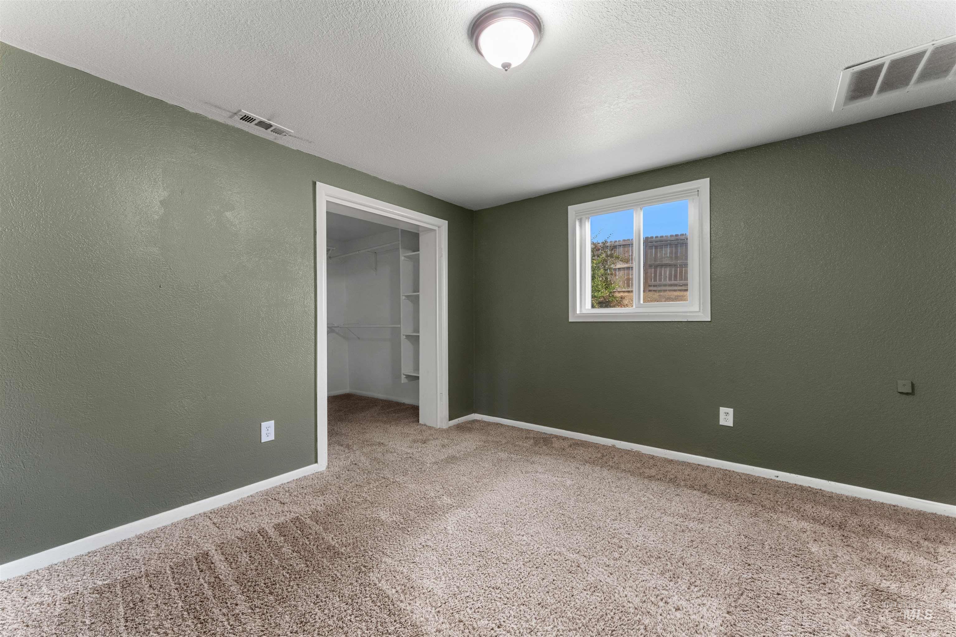 17441 Upper Pleasant Ridge Road Caldwell, ID 83607 - Photo 23 of 40 Carpeted room featuring a single window, a flush-mount ceiling light fixture, and a closet with built-in shelving