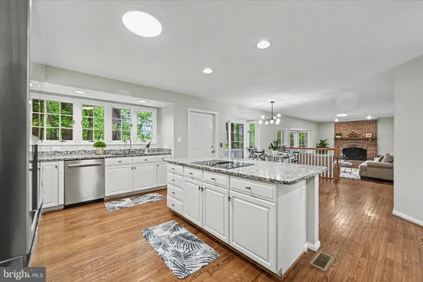 a kitchen with counter top space sink and wooden floor