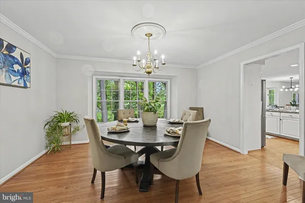 a dining room with furniture a large window and wooden floor