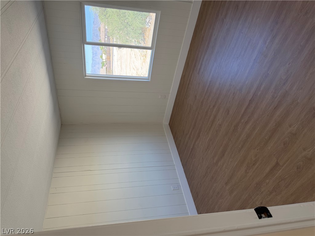 6401 Hafen Ranch Road Pahrump, NV 89061 - Photo 18 of 22 Smooth wood-look flooring and horizontal wall paneling frame a bright window in this versatile space.