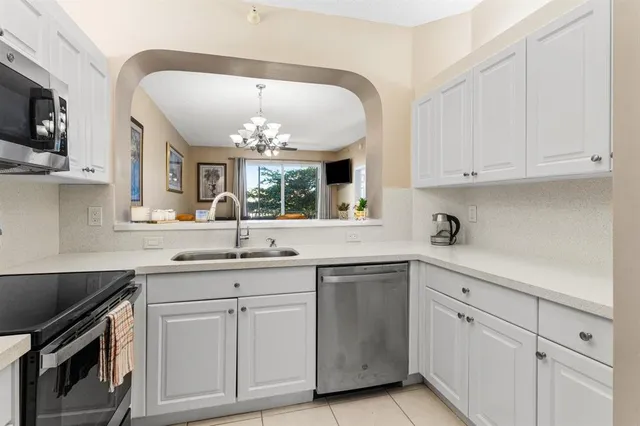 a kitchen with white cabinets and sink