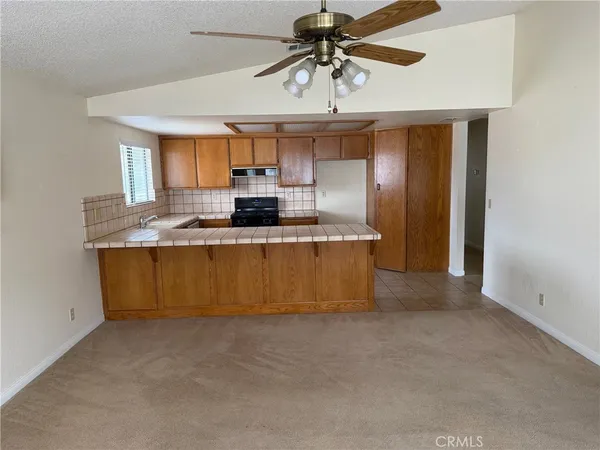 a kitchen with kitchen island granite countertop a sink window and stainless steel appliances