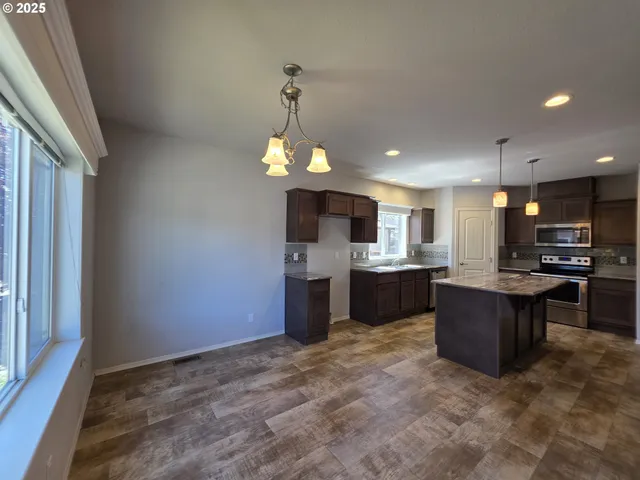 a kitchen with kitchen island a sink stainless steel appliances and cabinets