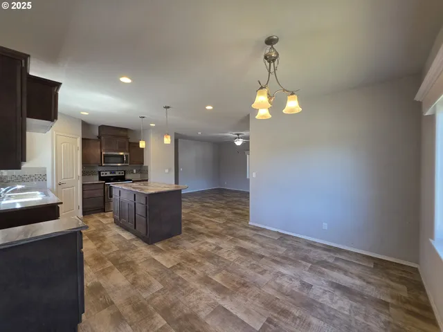 a kitchen with stainless steel appliances granite countertop a sink a stove and a refrigerator