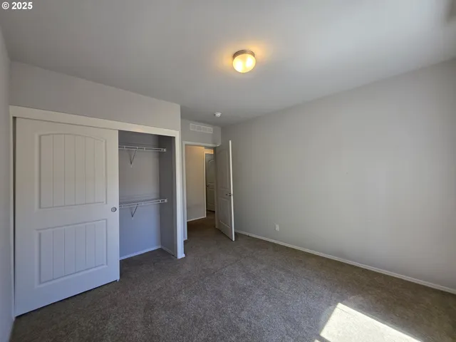 an empty room with closet and mirror