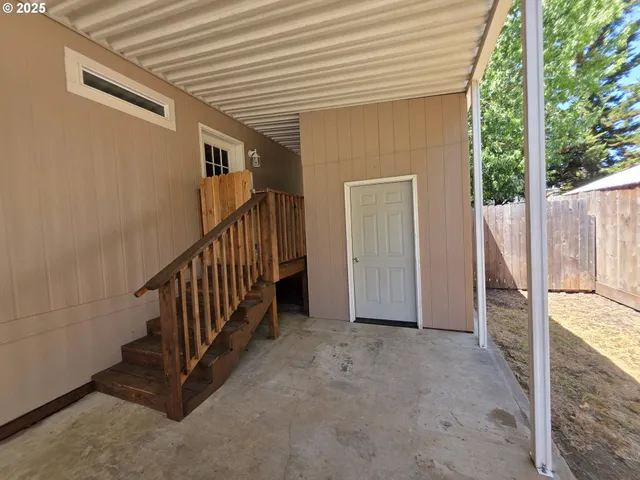 a view of a porch with wooden floor and fence
