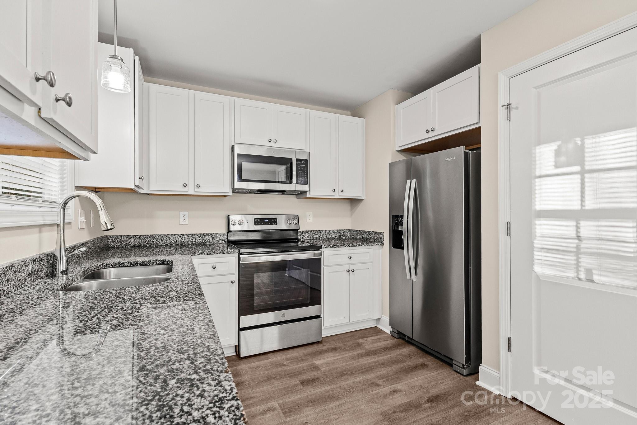 1219 Calhoun Street Rock Hill, SC 29732 - Photo 11 of 33 a kitchen with granite countertop a refrigerator stove and microwave