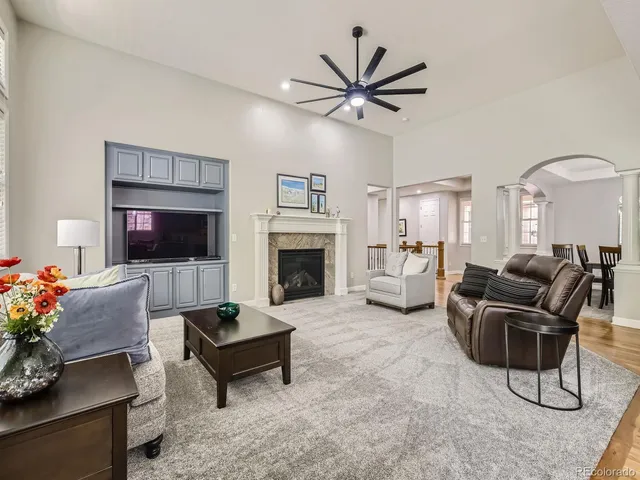 a living room with furniture a flat screen tv and a fireplace
