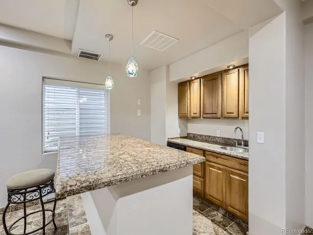 a kitchen with a stove a sink and a wooden cabinets
