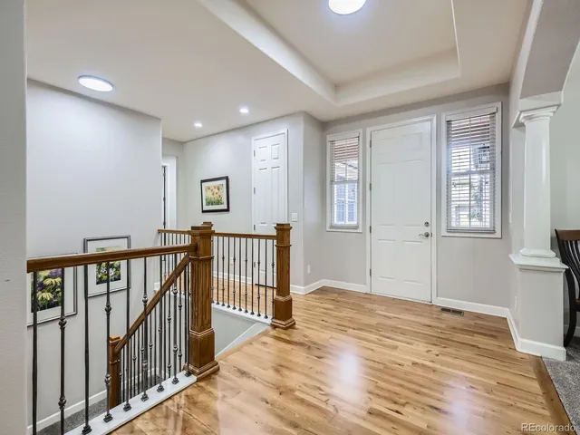 a view of a hallway with wooden floor and windows