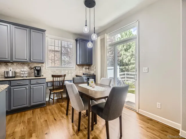 a kitchen with granite countertop a stove a sink a dining table and chairs