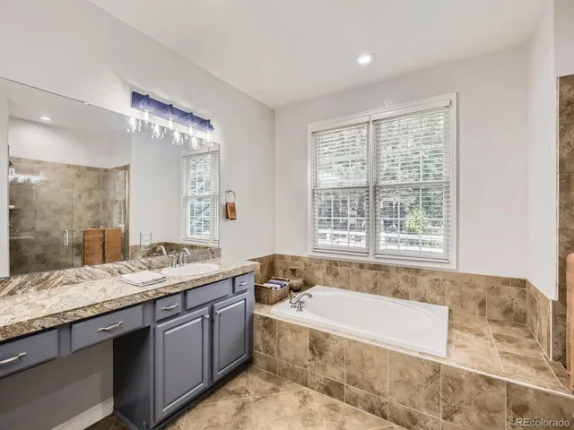 a spacious bathroom with a granite countertop tub sink and mirror