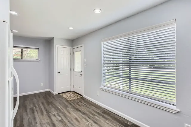 a view of a room with wooden floor and a window