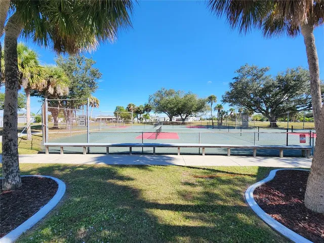 a view of a swimming pool with a yard and palm trees