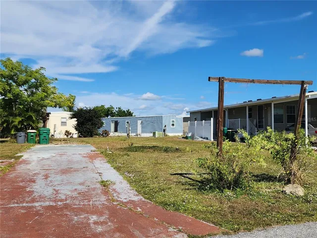 a view of a house with a yard and potted plants
