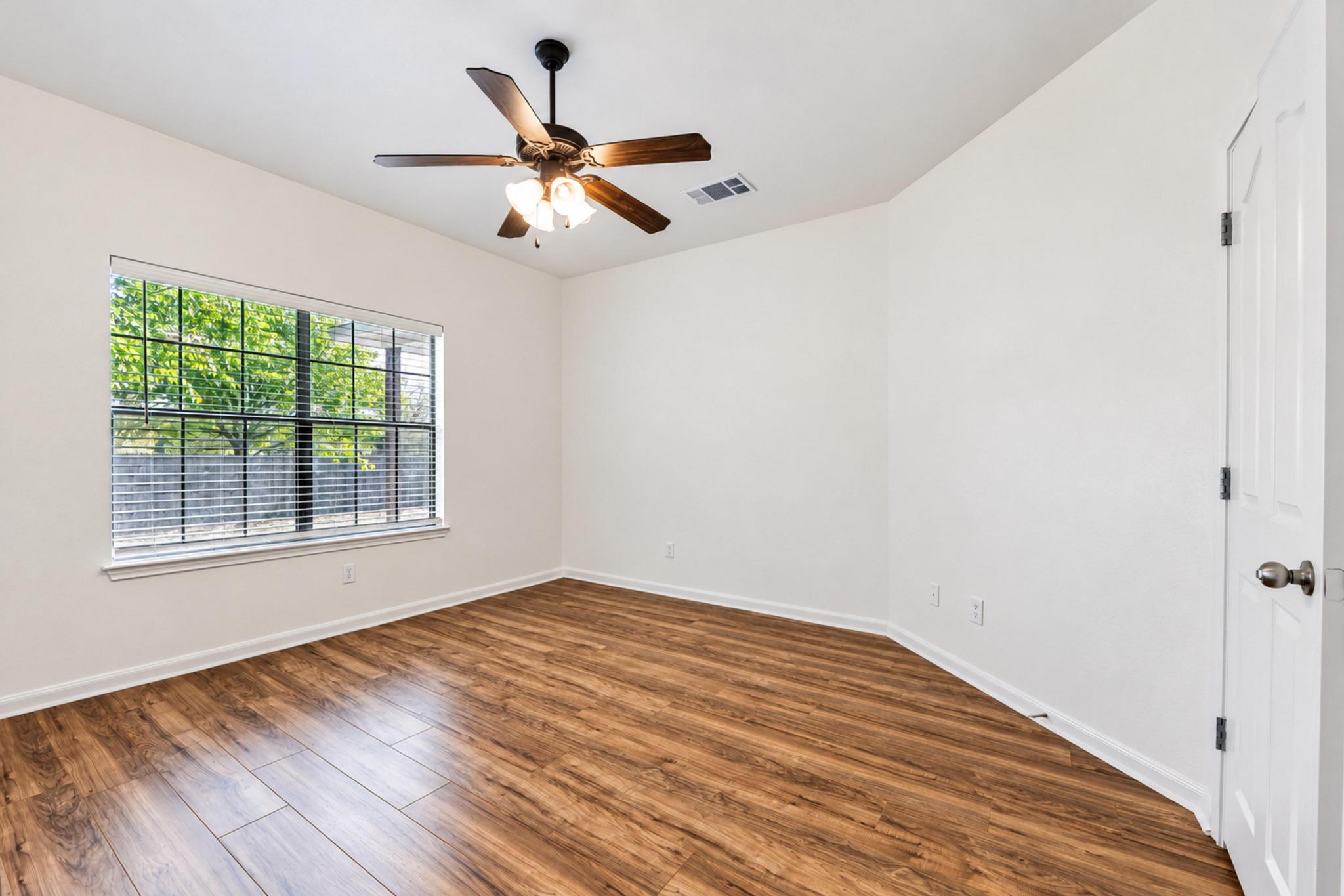 150 Engineers Pass Jarrell, TX 76537 - Photo 27 of 40 Warm wood-look flooring and a large window define this versatile secondary bedroom space.