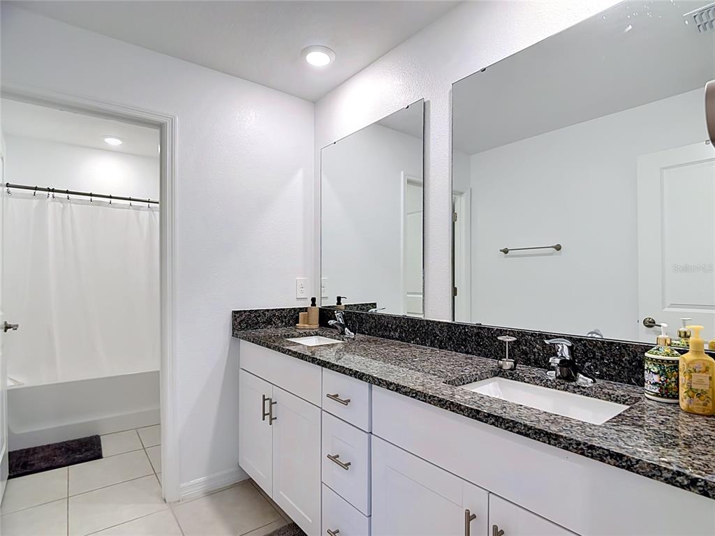 1633 Red Loop Lakeland, FL 33801 - Photo 34 of 60 a bathroom with a granite countertop sink and a mirror