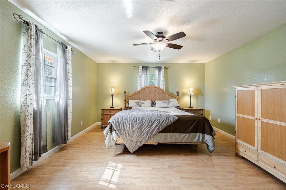 7764 14th Place LaBelle, FL 33935 - Photo 20 of 34 a bedroom with a large bed chandelier and a window