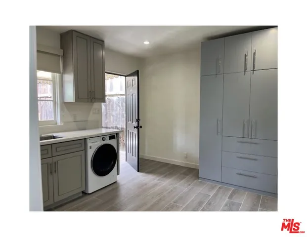 an empty room with windows and cabinet