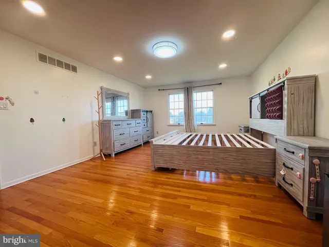 a spacious bedroom with a bed and a flat screen tv