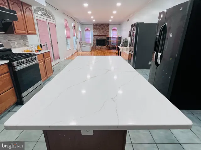 a large kitchen with stainless steel appliances a refrigerator and a stove top oven