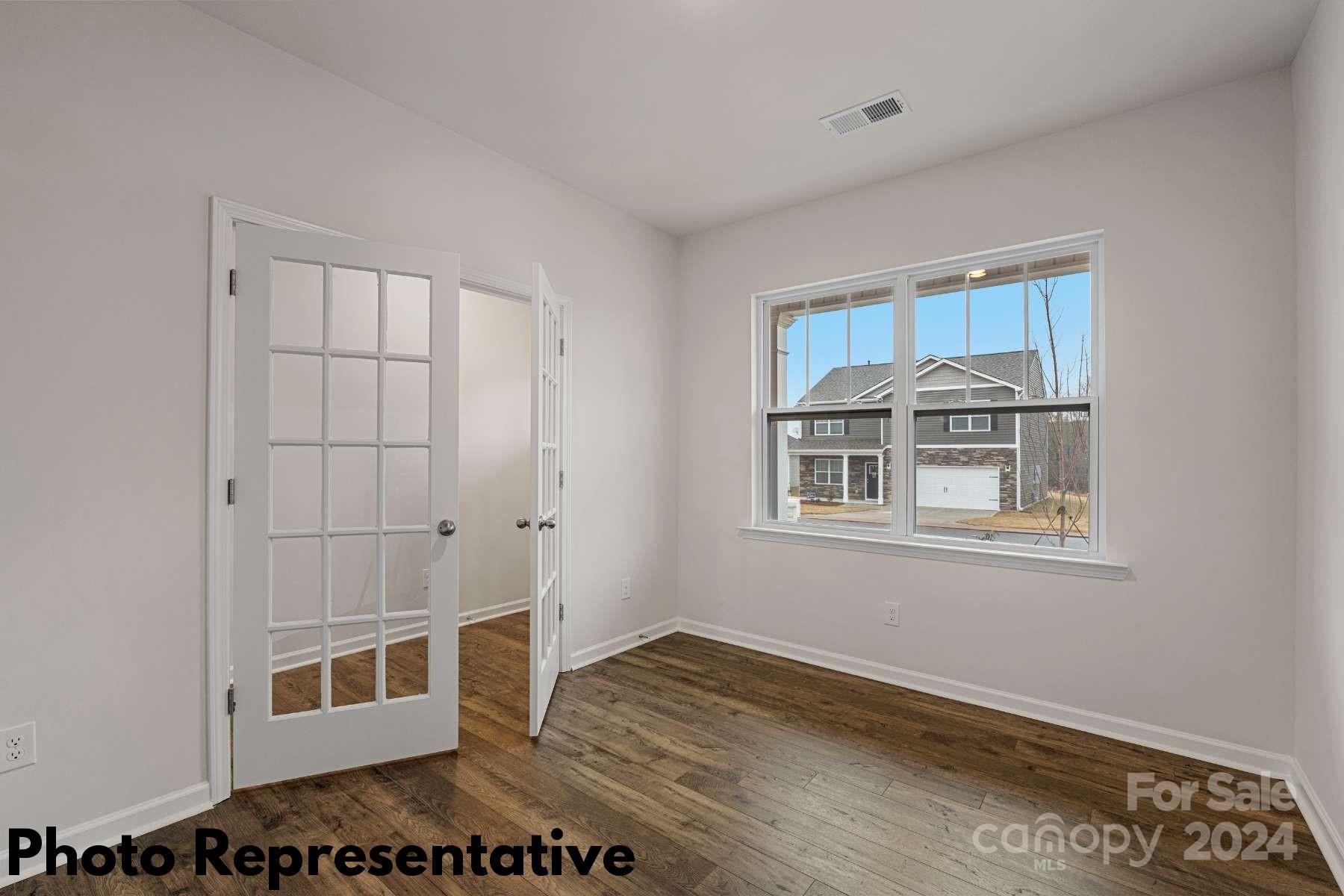 160 Dandelion Road Fletcher, NC 28732 - Photo 4 of 28 a view of an empty room with wooden floor and a window