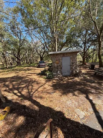 a view of a backyard with table and chairs and a large tree