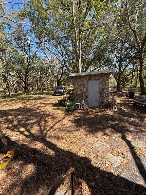 17233 Dalberg Drive Spring Hill, FL 34610 - Photo 12 of 24 a view of a backyard with table and chairs and a large tree