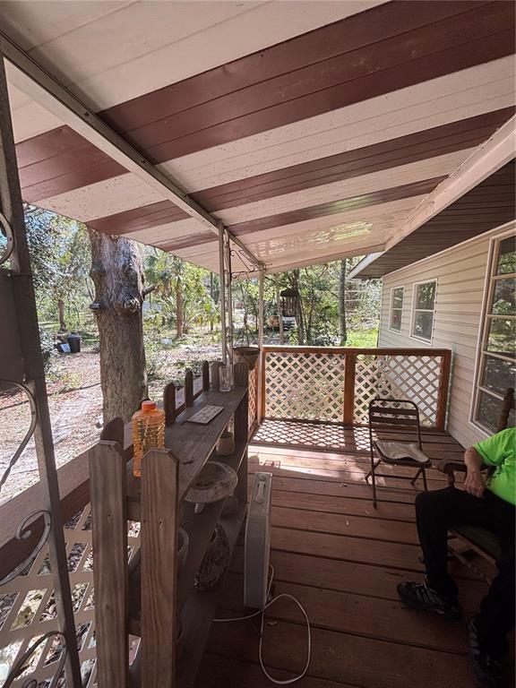 17233 Dalberg Drive Spring Hill, FL 34610 - Photo 14 of 24 a view of a patio with table and chairs potted plants with floor to ceiling window