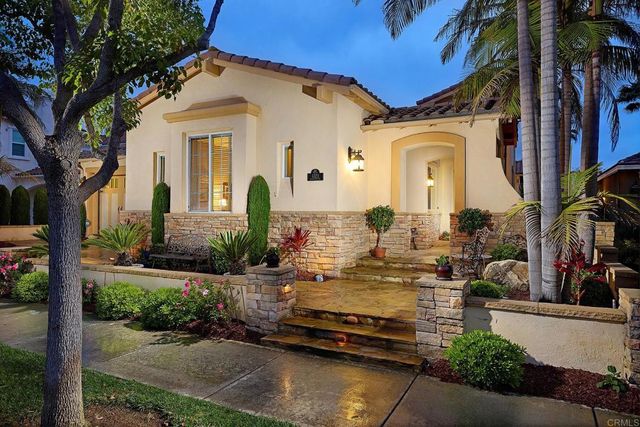 a backyard of a building with lots of flowers and trees