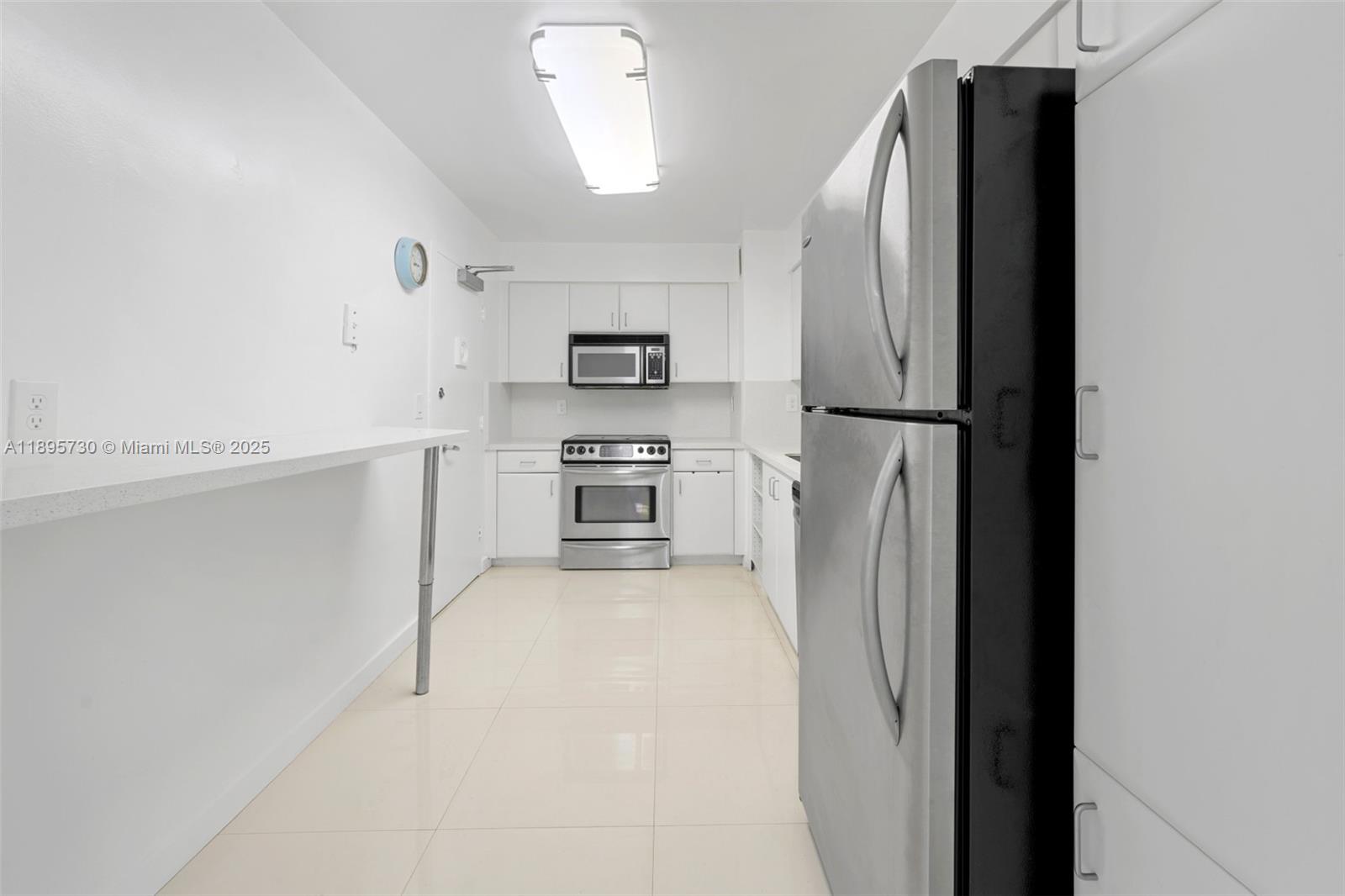 9195 Collins Avenue, Unit 812 Surfside, FL 33154 - Photo 11 of 20 a kitchen with stainless steel appliances a refrigerator sink and microwave