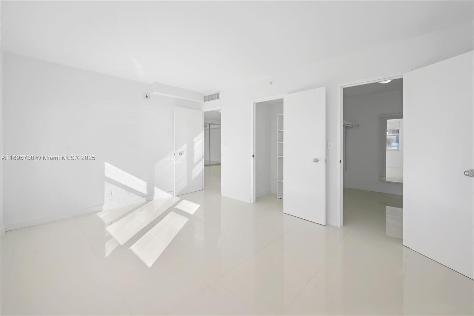 9195 Collins Avenue, Unit 812 Surfside, FL 33154 - Photo 13 of 20 a view of a room with white walls and a refrigerator