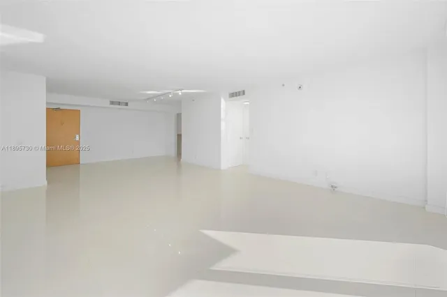 en empty room with windows and entrance