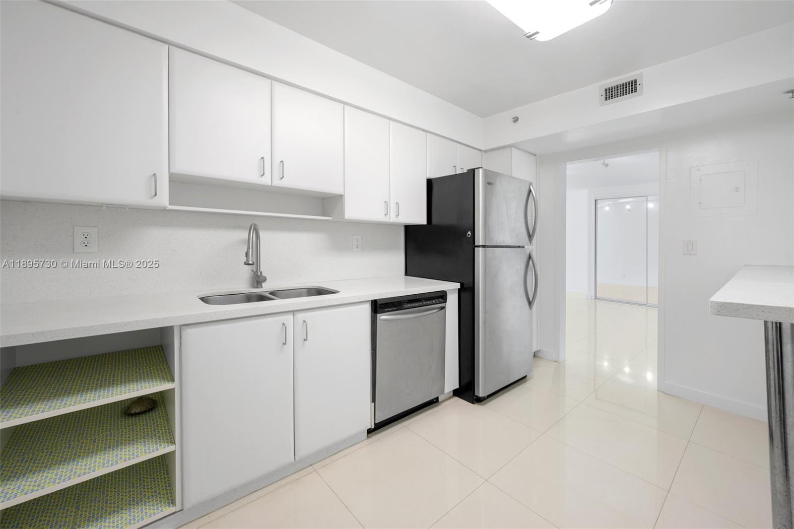 9195 Collins Avenue, Unit 812 Surfside, FL 33154 - Photo 10 of 20 a kitchen with a sink a refrigerator and cabinets